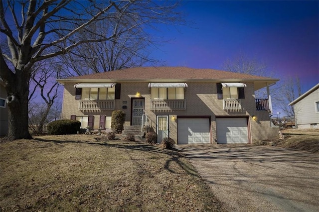 view of front facade with a garage, aphalt driveway, and brick siding