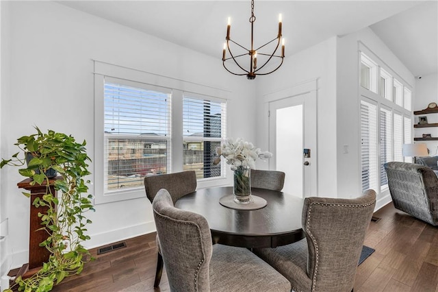 dining room with dark wood-type flooring, visible vents, baseboards, and an inviting chandelier