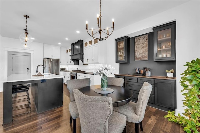 dining area with a notable chandelier, dark wood-style flooring, and recessed lighting