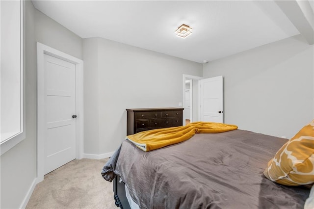 bedroom featuring light carpet and baseboards