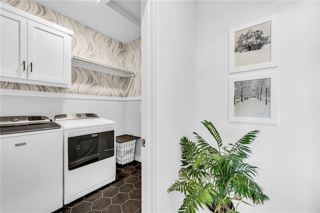 washroom with cabinet space, dark tile patterned floors, wallpapered walls, and independent washer and dryer