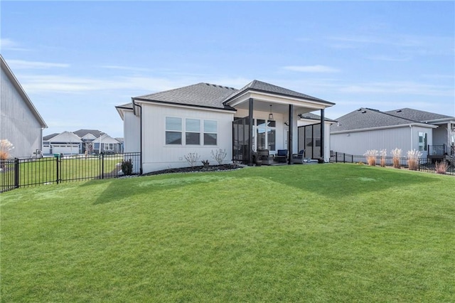 view of front of home featuring a shingled roof, a front yard, a fenced backyard, and a residential view