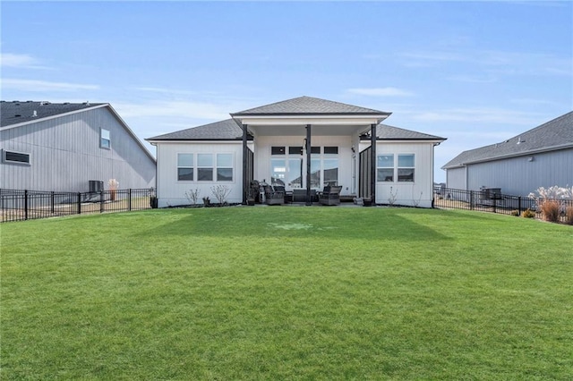 back of house with a fenced backyard and a yard