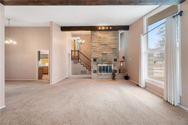 unfurnished living room with beam ceiling, carpet, a notable chandelier, and a fireplace