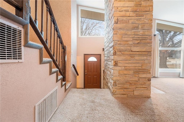 foyer featuring a towering ceiling and carpet floors