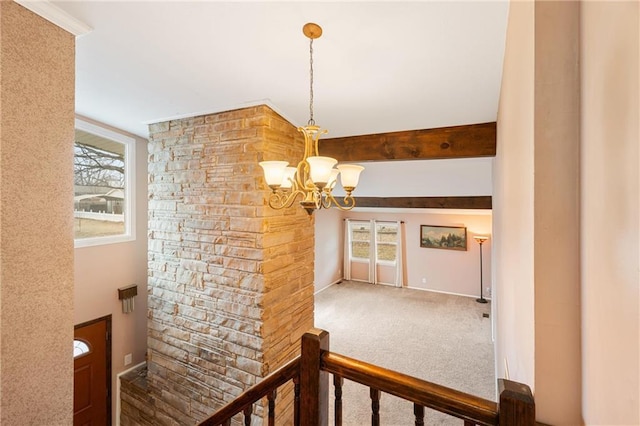 hallway featuring an inviting chandelier, beamed ceiling, and carpet