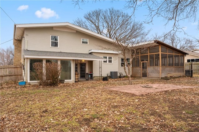 rear view of house with cooling unit, a patio area, and a sunroom