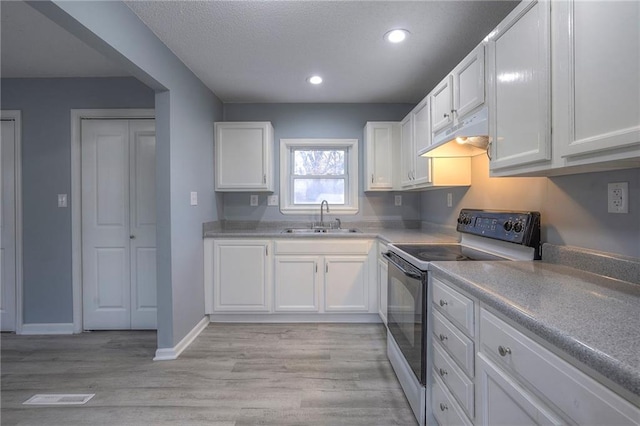 kitchen with sink, light hardwood / wood-style flooring, white cabinets, and electric stove