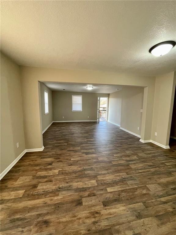 empty room with dark hardwood / wood-style flooring and a textured ceiling