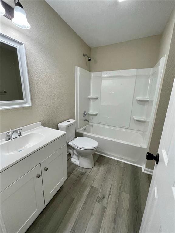 full bathroom with toilet, vanity, bathtub / shower combination, and hardwood / wood-style floors