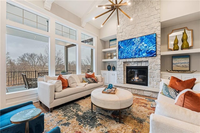 living room with beam ceiling, a notable chandelier, wood finished floors, and built in shelves