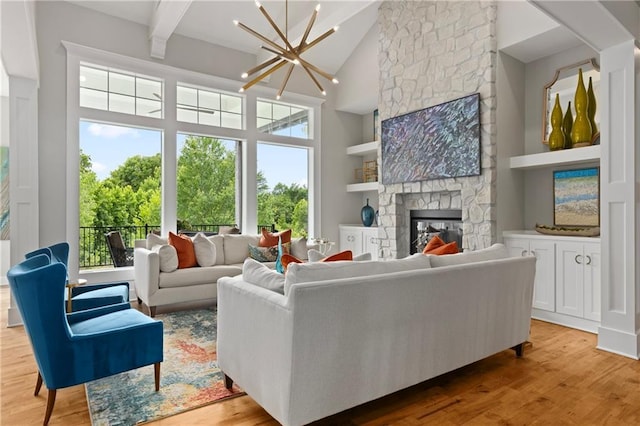 living room with a healthy amount of sunlight, an inviting chandelier, and wood finished floors