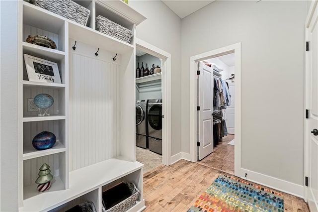 mudroom featuring baseboards, light wood finished floors, and washer and clothes dryer