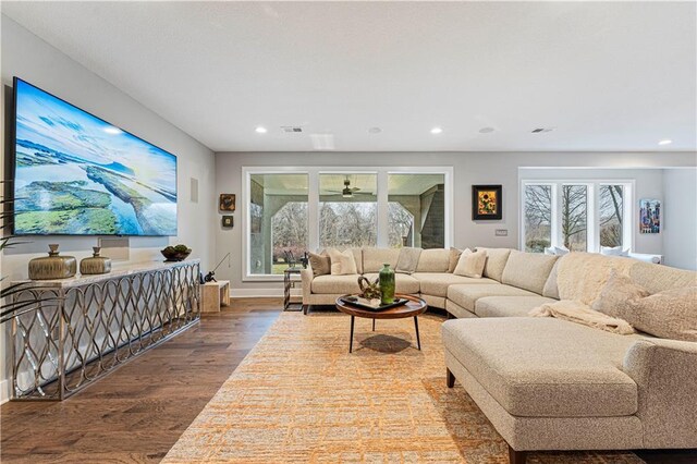 living room with recessed lighting, wood finished floors, visible vents, and baseboards