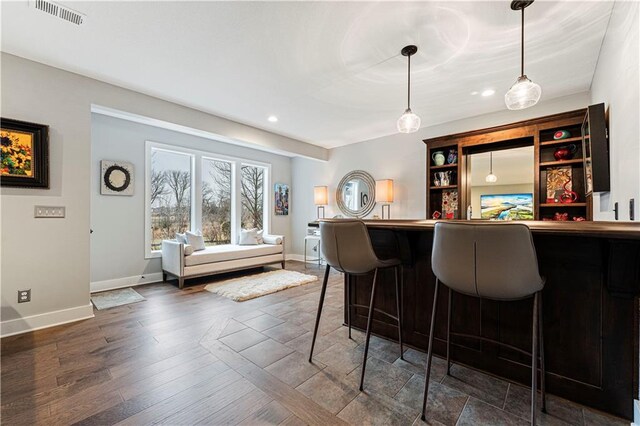 bar featuring visible vents, baseboards, and a dry bar