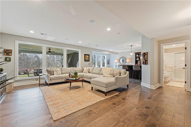 living area featuring hardwood / wood-style flooring, recessed lighting, baseboards, and visible vents