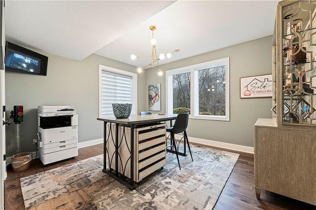 office area featuring dark wood-style floors, an inviting chandelier, a textured ceiling, and baseboards