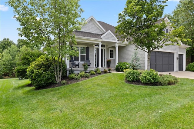 view of front of house with a garage, covered porch, and a front lawn