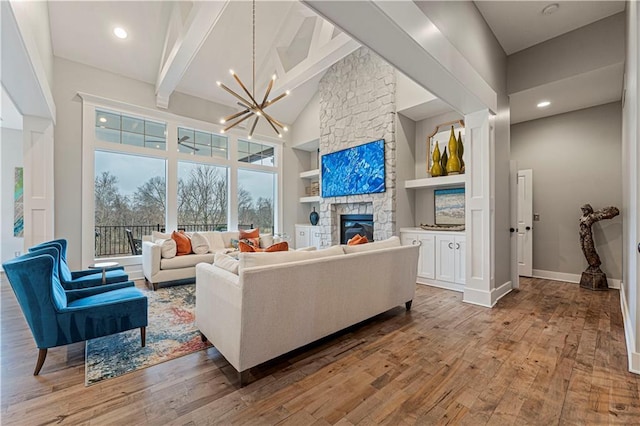 living room featuring high vaulted ceiling, beamed ceiling, a stone fireplace, and hardwood / wood-style flooring