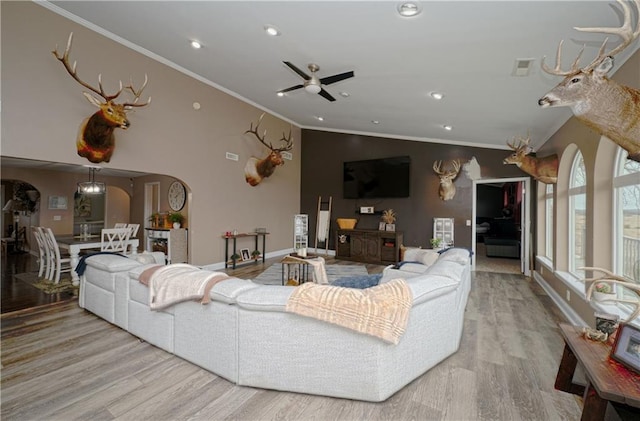 living room with crown molding, lofted ceiling, ceiling fan, and light wood-type flooring