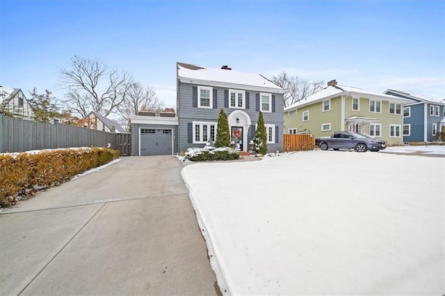 view of front facade featuring a residential view, driveway, an attached garage, and fence