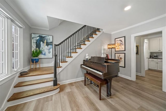 foyer entrance with light wood-style flooring, recessed lighting, baseboards, stairway, and crown molding