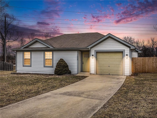 ranch-style home featuring a garage and a yard