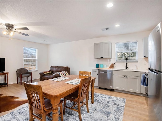 dining room featuring plenty of natural light, light hardwood / wood-style floors, and sink