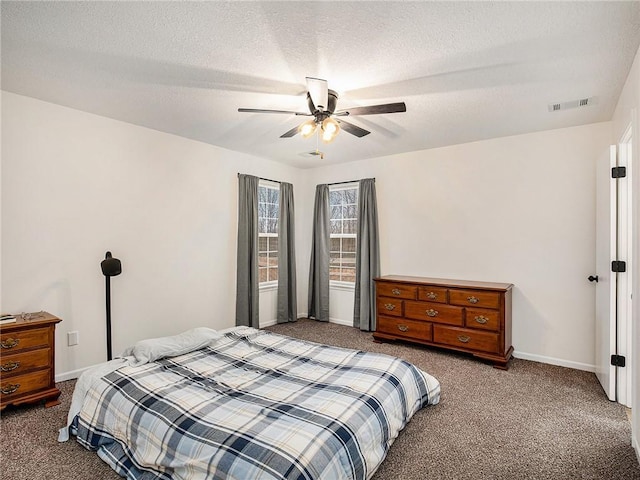 carpeted bedroom with ceiling fan and a textured ceiling