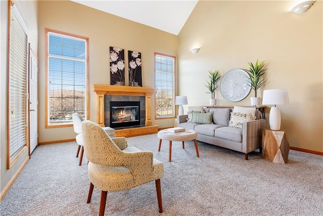 carpeted living room with high vaulted ceiling, a tile fireplace, and baseboards