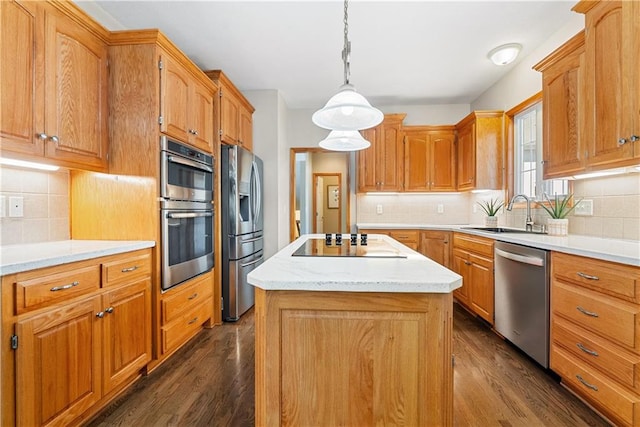 kitchen featuring appliances with stainless steel finishes, a center island, light countertops, and dark wood-type flooring