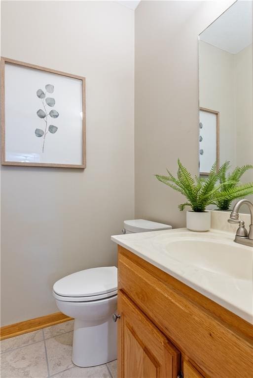 bathroom featuring toilet, baseboards, vanity, and tile patterned floors