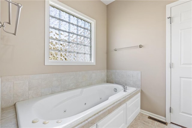 bathroom featuring a tub with jets, visible vents, baseboards, and tile patterned floors