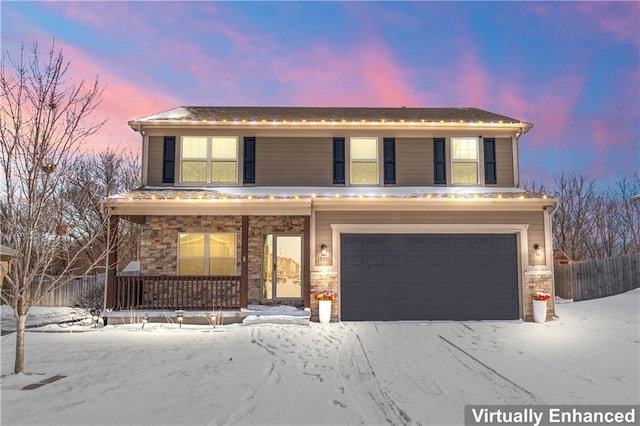 traditional home featuring an attached garage, stone siding, fence, and covered porch