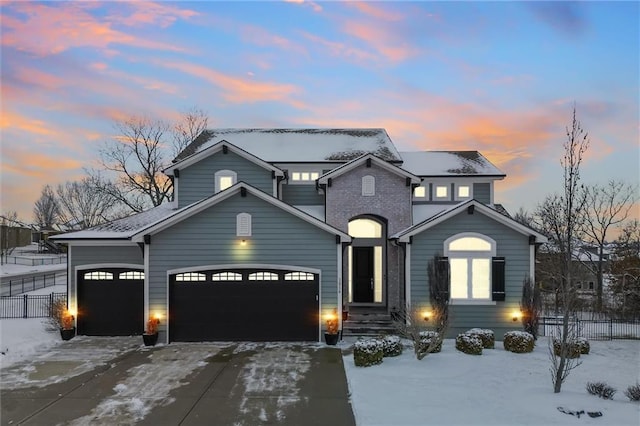 traditional-style home with driveway, brick siding, an attached garage, and fence