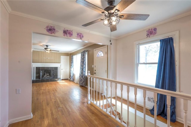 interior space with baseboards, wood finished floors, an upstairs landing, and crown molding