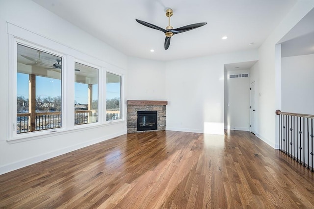 unfurnished living room with wood-type flooring, a fireplace, and ceiling fan