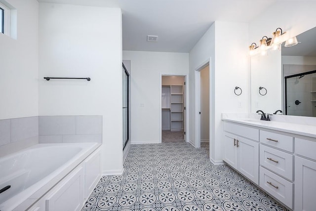 bathroom featuring independent shower and bath, vanity, and tile patterned flooring