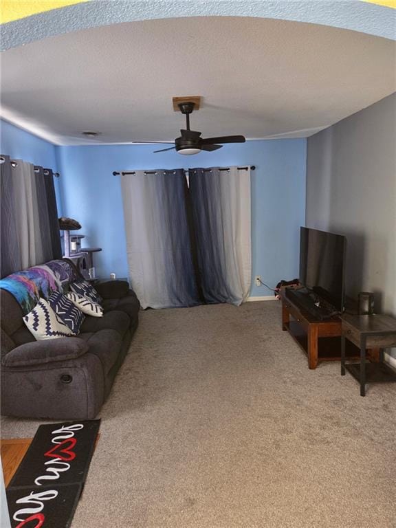 living room featuring ceiling fan, carpet flooring, and a textured ceiling