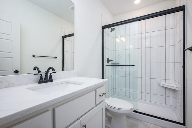 bathroom featuring vanity, a shower with shower door, and toilet