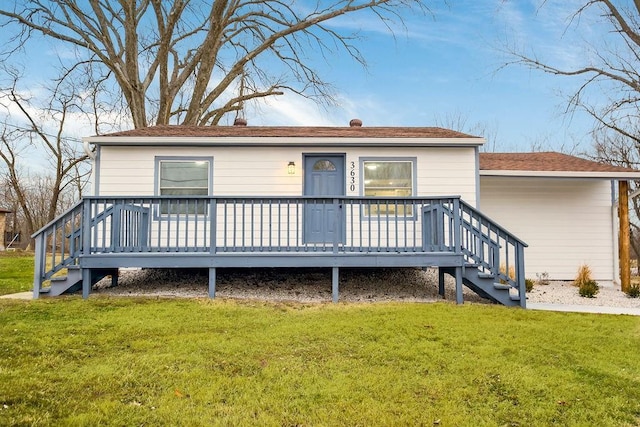 rear view of house with a deck and a lawn