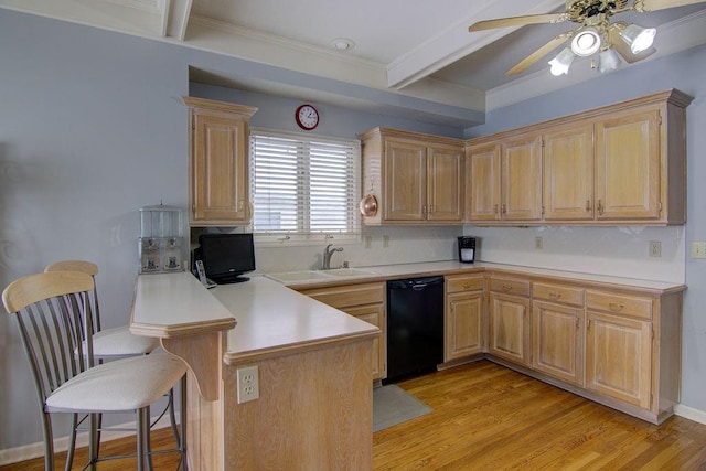 kitchen featuring light brown cabinetry, dishwasher, sink, a kitchen bar, and kitchen peninsula