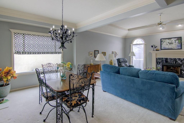 carpeted dining room with a fireplace, ceiling fan, and crown molding