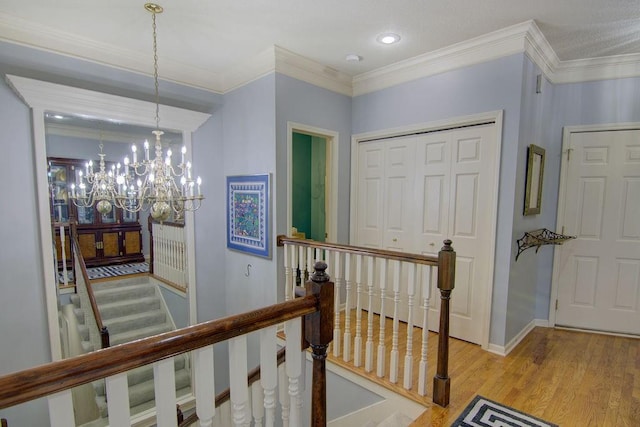 hallway featuring crown molding, a notable chandelier, and light hardwood / wood-style flooring