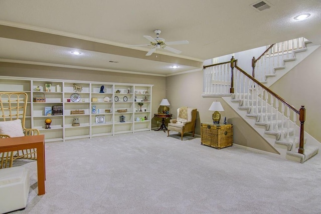 sitting room with ceiling fan, carpet flooring, and crown molding