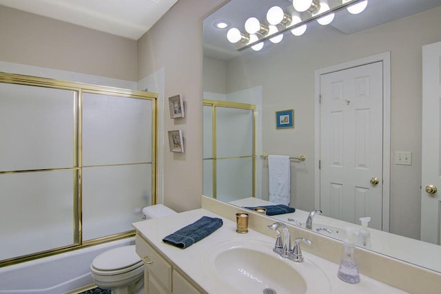 full bathroom with bath / shower combo with glass door, vanity, and toilet