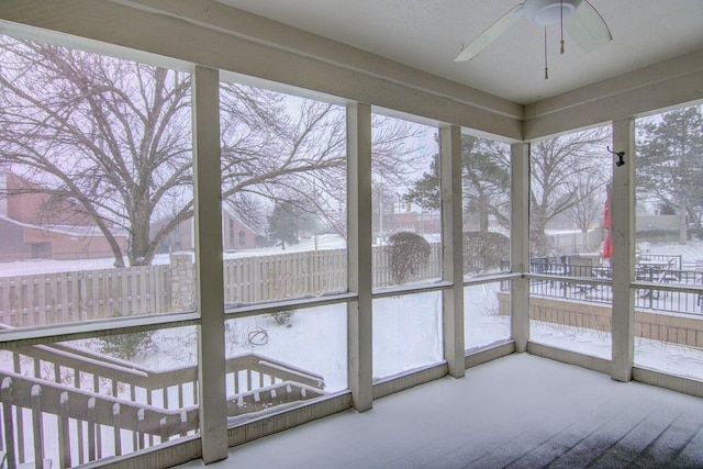 unfurnished sunroom with ceiling fan