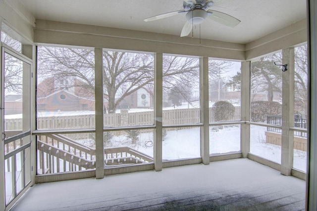 unfurnished sunroom featuring ceiling fan