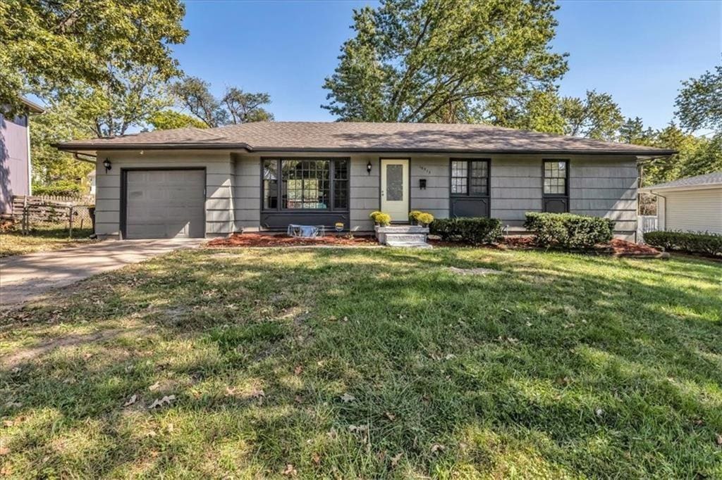 single story home with a garage and a front yard