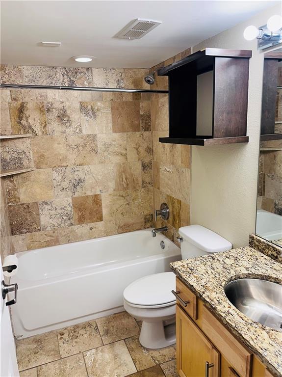 full bathroom with vanity, toilet, and tiled shower / bath combo